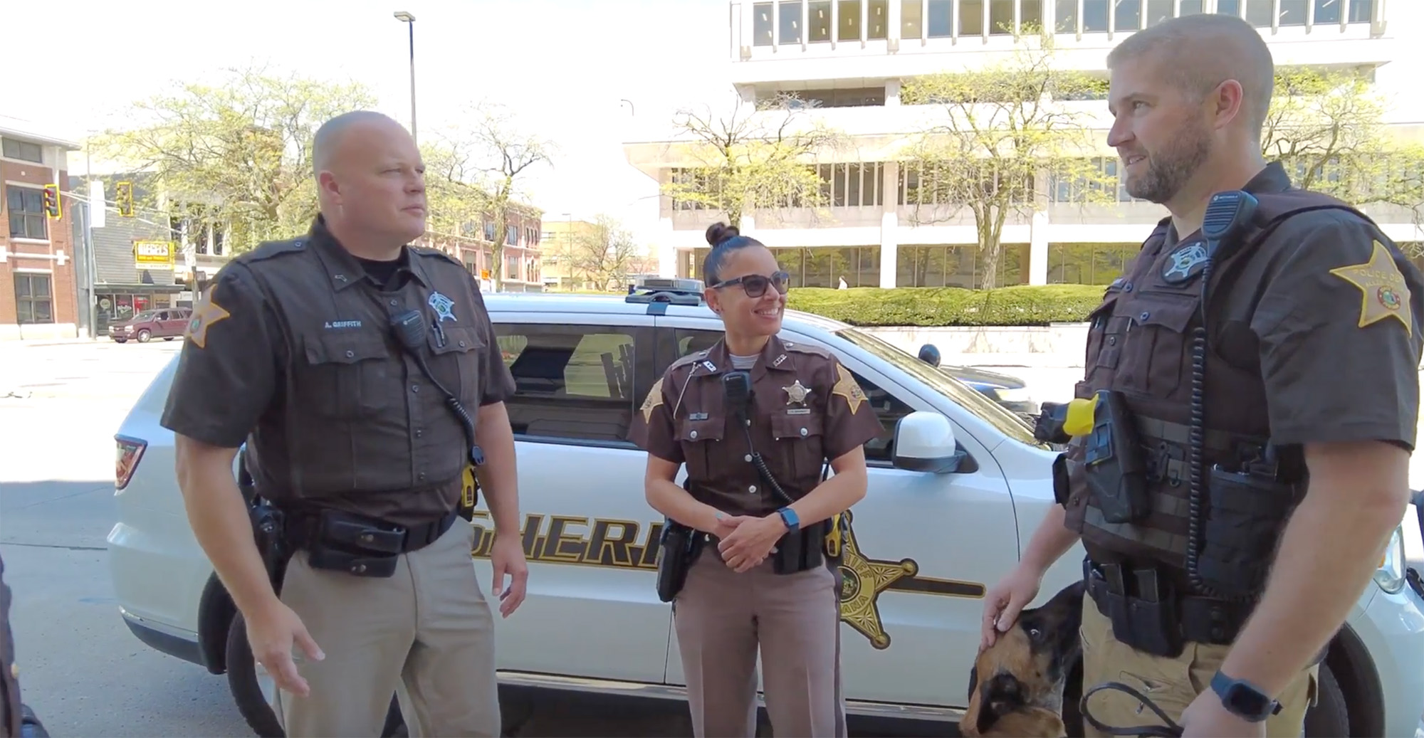 Three police officers standing and talking on sidewalk